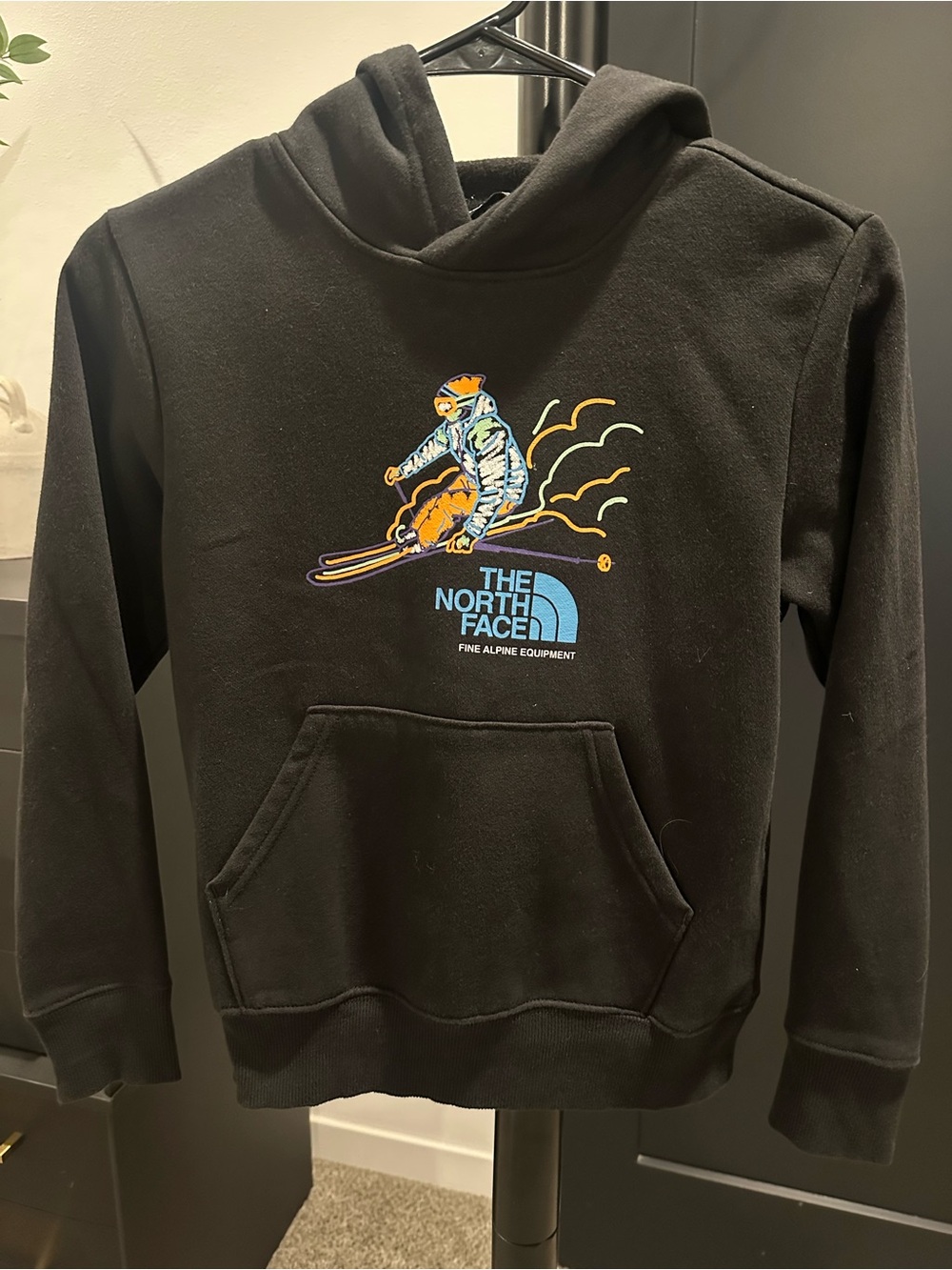 The North Face Black Hoodie with Colorful Skier Graphic